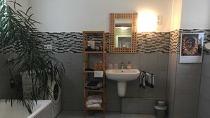 A bathroom with a sink, mirror, shelves, a plant, a washing machine, and a striped rug. - Vacation apartment B, Salzgasse, Old Town - Edition Bad Wimpfen (Bad Wimpfen)