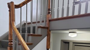 A staircase with wooden handrails and a gray carpeted landing. - All in Reach, 2BR in West End (Nashville)