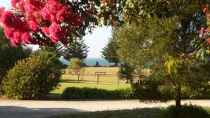 Ein Park mit einem Weg, B änken und Blick auf das Meer.