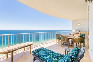 A balcony with a view of the ocean, wooden furniture, and a small kitchen area. - Weekend getaway starts here !  3 bdr gulf front sleeps 8 Lovely condo! C tower (Orange Beach)