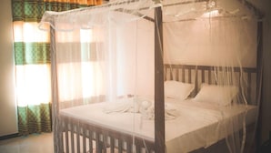 A four-poster bed with a canopy, a window with curtains, and a tiled floor. - Tanoaks Villa (Mirissa)