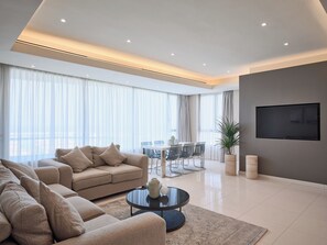 A modern living room with a sofa, coffee table, and dining area.