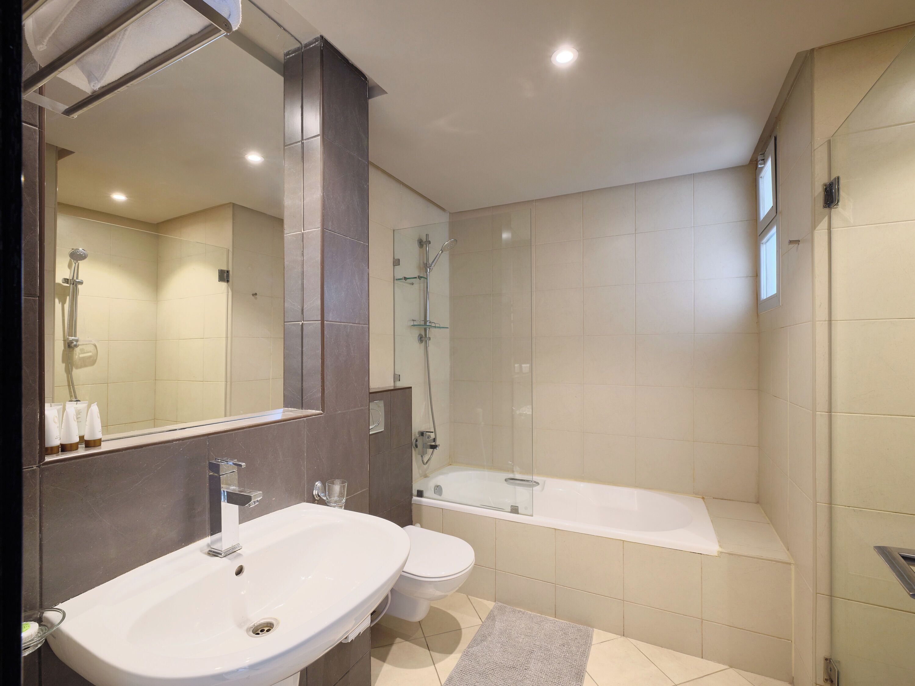 Un bagno moderno con lavandino, WC, doccia e vasca da bagno.