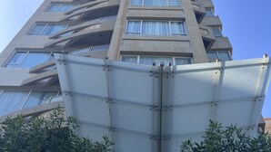 A tall, modern building with a unique architectural design, featuring multiple balconies and large windows. - Code Housing - Fintas (Fintas)