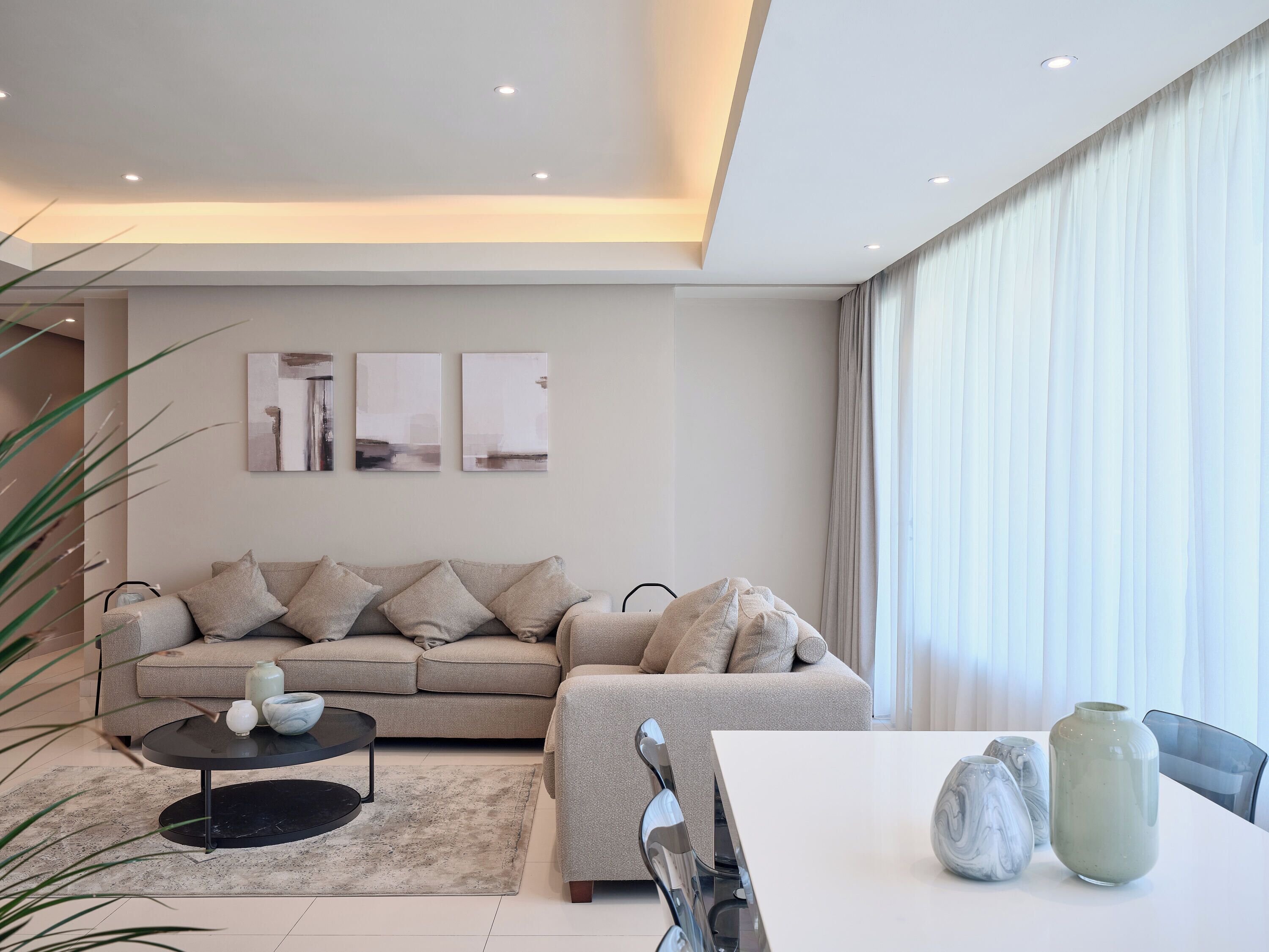 A modern living room with a sofa, a coffee table, and decorative vases.