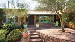 Une maison dotée d’un patio, d’un espace salon extérieur et d’un jardin.