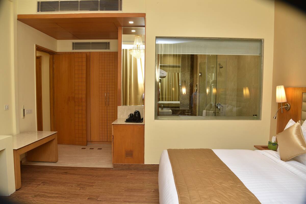 Een hotelkamer met een bed, een bureau, een spiegel en een raam.