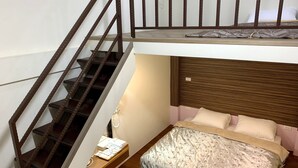 A compact room with a bunk bed, a desk with a chair, and a staircase. - Jia's Homestay (Lugu)