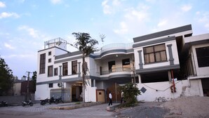Una casa moderna de dos pisos con balcón, garaje y entrada para vehículos.