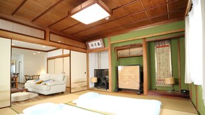 A traditional Japanese-style room with tatami flooring, a low wooden bed, a tatami mat table, and a sliding door leading to another room. - 4A House for Family with tatami (大阪市浪速区大国3-4-6)