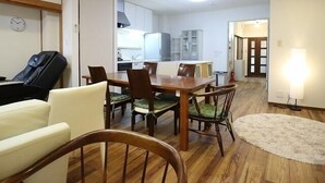 A compact living space with a dining area, a massage chair, and a kitchenette. - 4A House for Family with tatami (大阪市浪速区大国3-4-6)
