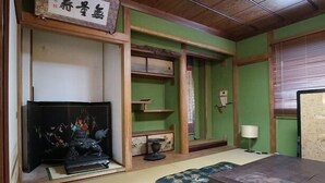 A traditional Japanese room with tatami flooring, a low wooden table, cushions, a television, and a shoji screen. - 4A House for Family with tatami (大阪市浪速区大国3-4-6)