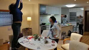 A modern living room with a round table, a sofa, and a kitchen in the background. - 3A Spacious room with Built-in Kitchen (Ōsaka-shi)