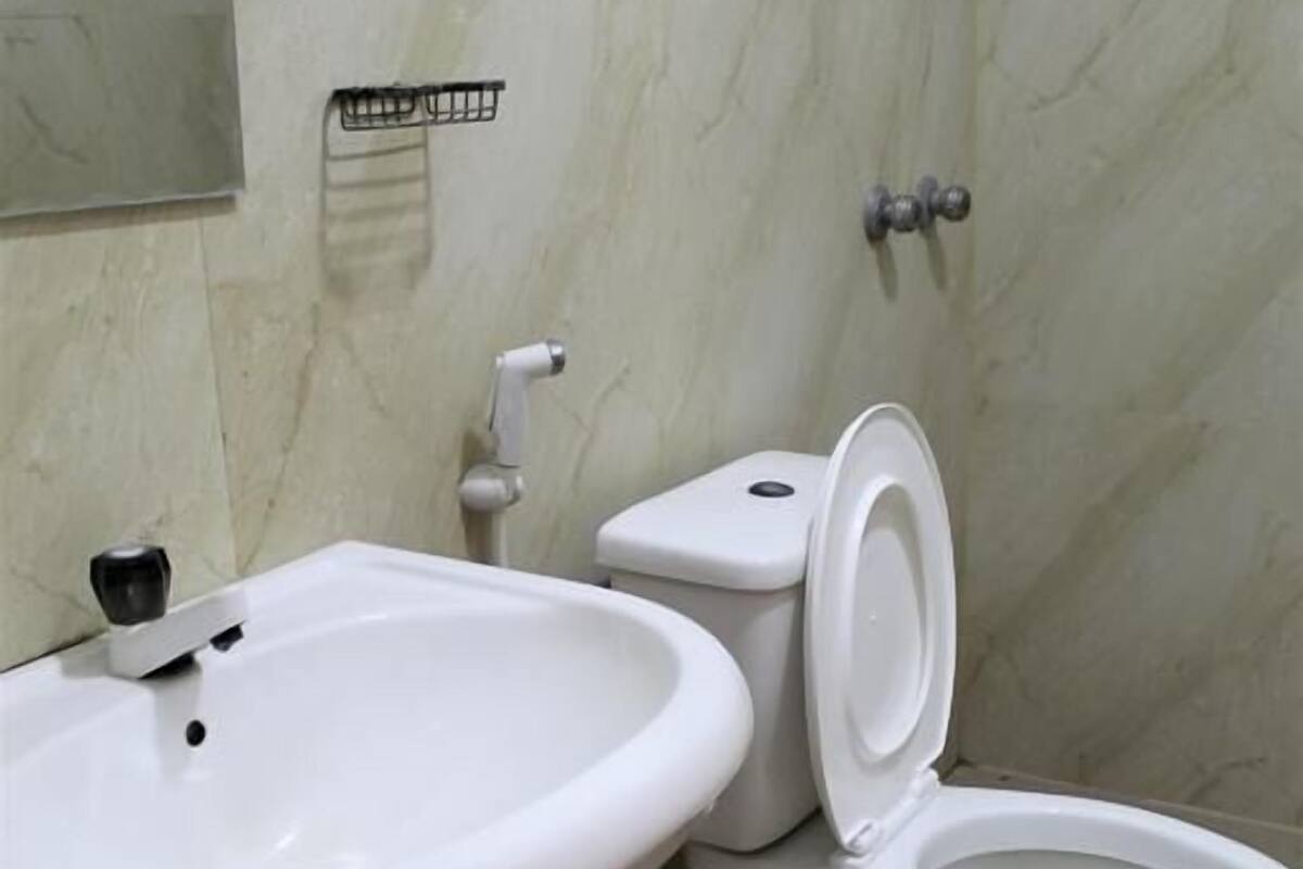 A bathroom with a white sink, toilet, and marble walls.