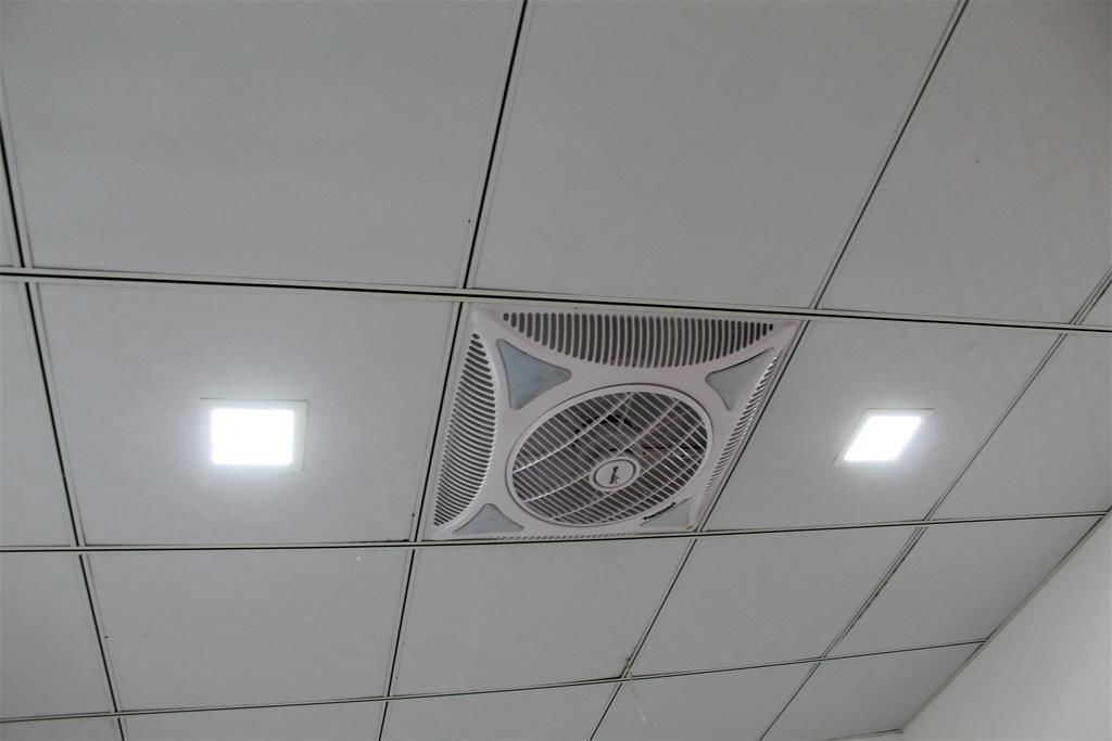 Un plafond doté d’une bouche d’aération centrale et de deux luminaires carrés.