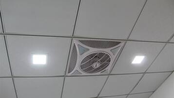 Un plafond doté d’une bouche d’aération centrale et de deux luminaires carrés.
