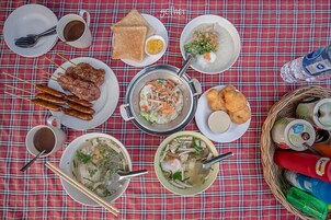 Una mesa con diferentes platos, incluyendo brochetas, sopa y pan, que sugiere un ambiente para comer.