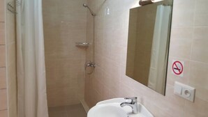 A bathroom with a shower, sink, and mirror. - Sky Hotel (Bishkek)