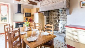 Una cocina rústica con paredes de piedra vista, vigas de madera y piso de baldosas.