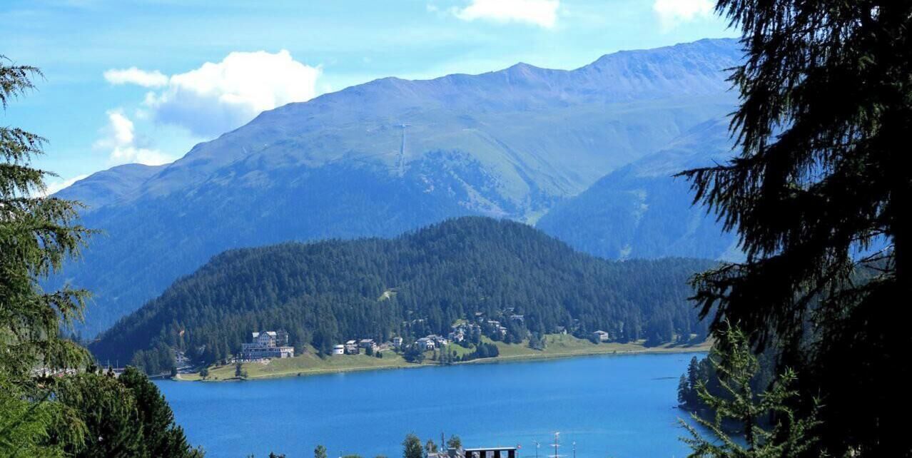 Un paysage montagneux avec un lac et un petit village.