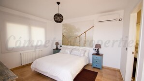A bedroom with a bed, nightstands, a lamp, a radiator, and a window. - New luxury villa, 5 bedrooms, 5 bathrooms, private pool (Canillas de Albaida)
