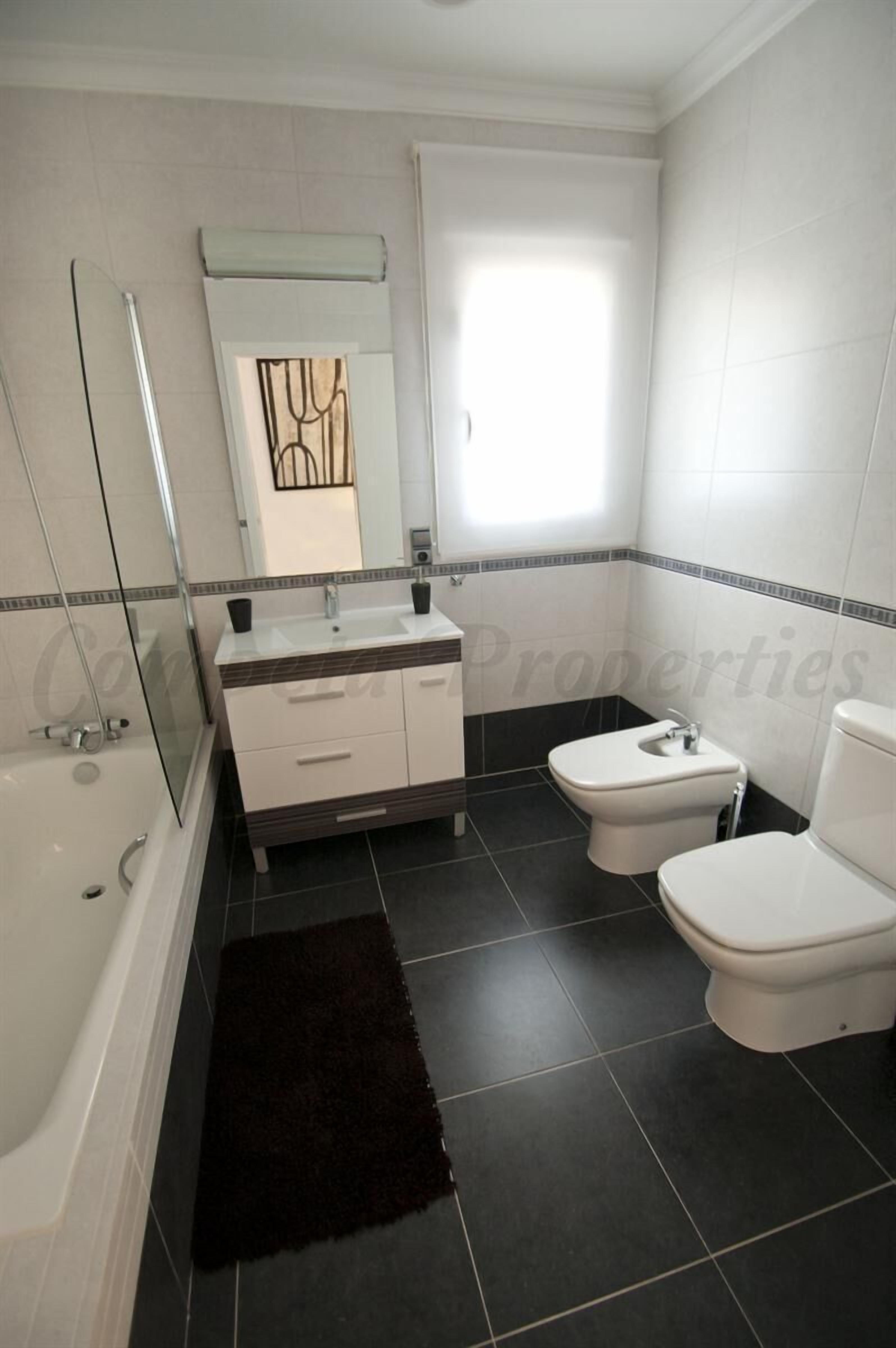 Une salle de bain avec une baignoire, des toilettes et un bidet.