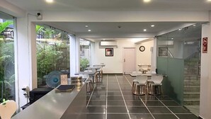 A modern hotel lobby with a check-in counter, seating area, and a staircase. - The Residency (Kolkata)
