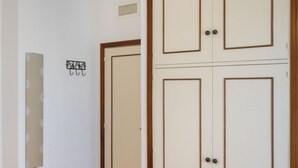 Una habitación con una puerta, un respiradero y una pared parcialmente visible con un cartel.