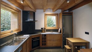 Une cuisine moderne avec des meubles en bois, un évier en acier inoxydable et un four encastré.