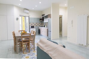 A modern kitchen with a microwave, stove, and cabinets. There is a dining table with chairs and a patterned rug.
