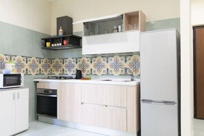 Une cuisine compacte équipée d’un four à micro-ondes, d’un four, d’un évier et d’un réfrigérateur.