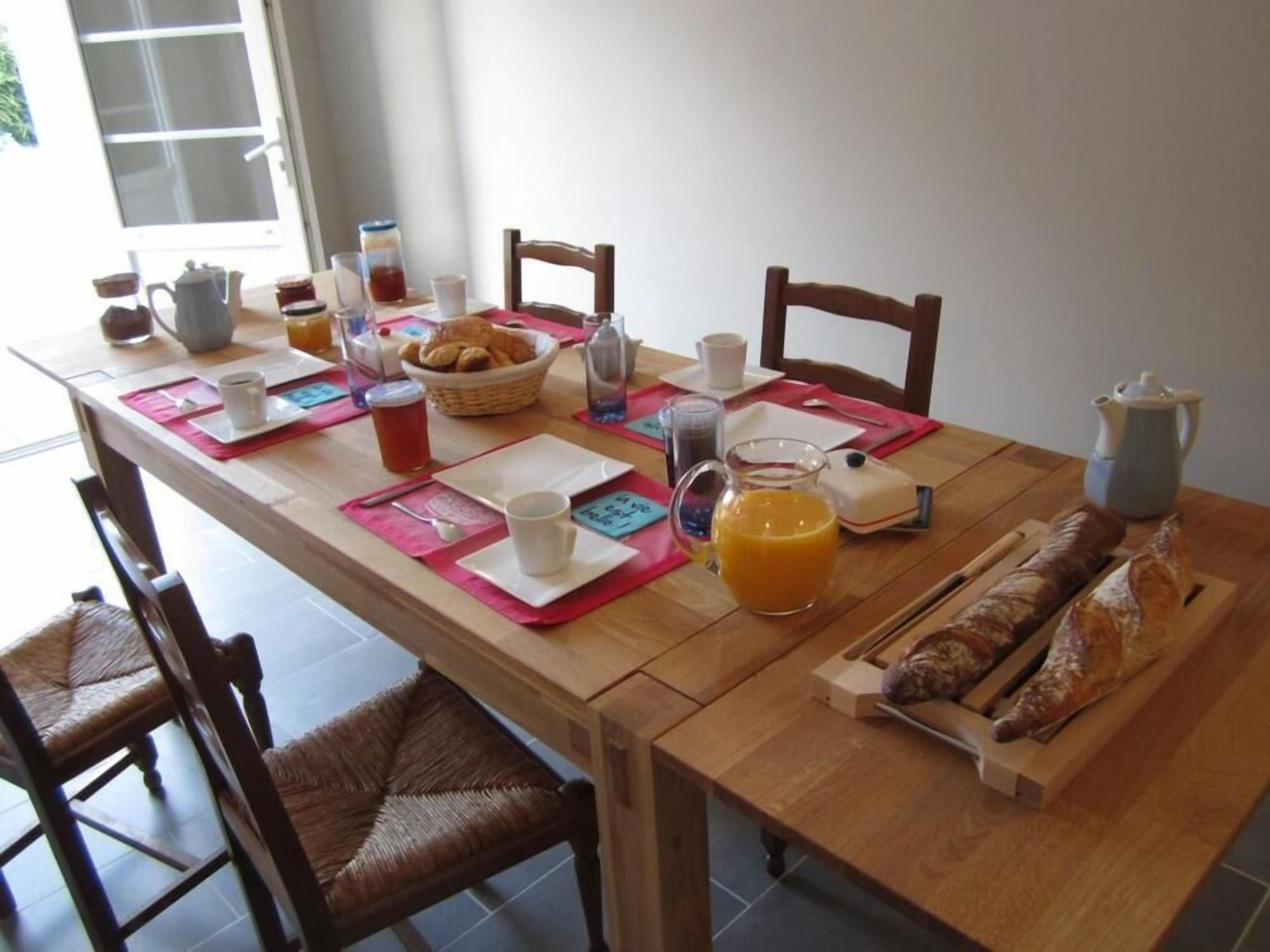 A breakfast table set with various breakfast items, including bread, pastries, and beverages.