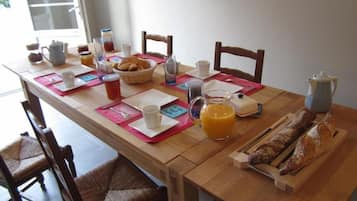 A breakfast table set with various breakfast items, including bread, pastries, and beverages.