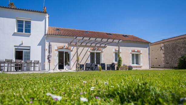 A two-story building with a covered patio and a grassy lawn. - Les Cagouilles (Virson)