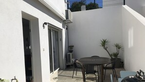 A patio with a table and chairs, a grill, and potted plants. - RENTED VILLA F3 RENTED IN THE GREEN AREA (Sainte-Maxime)