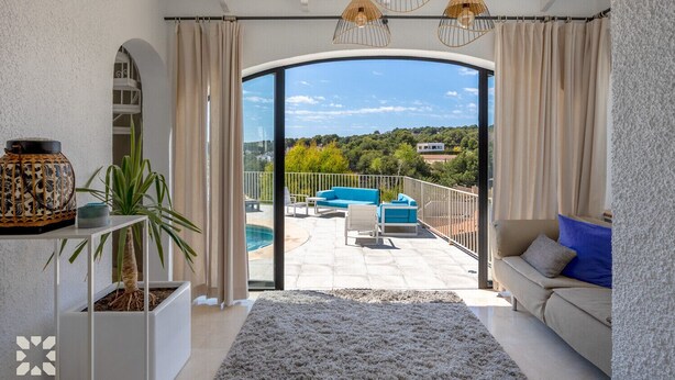 Een ruim balkon met een zwembad, een bank en uitzicht op het landschap.