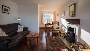 Una sala de estar acogedora con un sofá de cuero, una mesa de centro de madera y una chimenea.