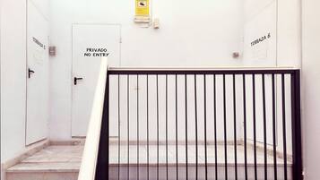 Una escalera con barandilla metálica que lleva a una puerta con la leyenda 'Privado No Entry'.