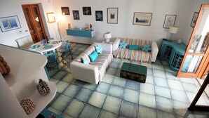 Un salon avec un canapé, une table et un meuble bleu.