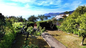 Un sentier de jardin qui mène à un point de vue sur une étendue d’eau et des montagnes.