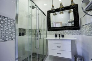 Departamento familiar, 1 cama King size, vista al jardín | Baño | Regadera, amenidades de baño gratuitas, secadora de cabello, toallas