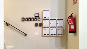 Ett väggmonterat brandlarmssystem, en brandsläckare och en uppsättning intercomsystem.