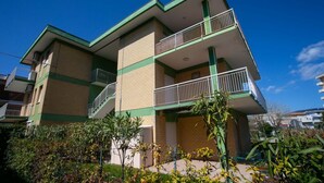 A multi-story building with balconies, a staircase, and a garden area. - M027 - Marcelli, three-room apartment with terrace 150 meters from the sea (Marcelli)