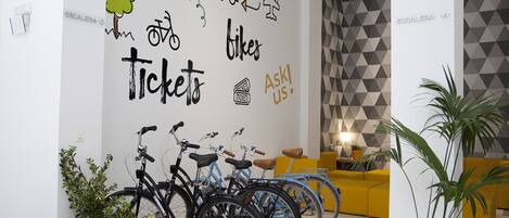 Un interior moderno con bicicletas, una pared con ilustraciones de viajes y una pared con un diseño geométrico.