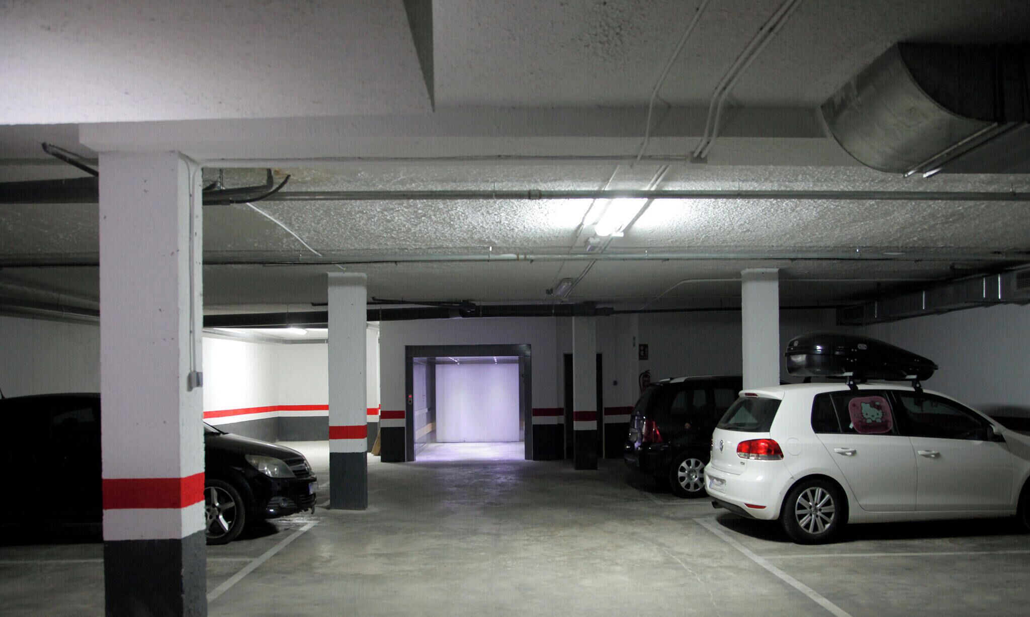 Un parking à plusieurs niveaux où sont stationnées plusieurs voitures.