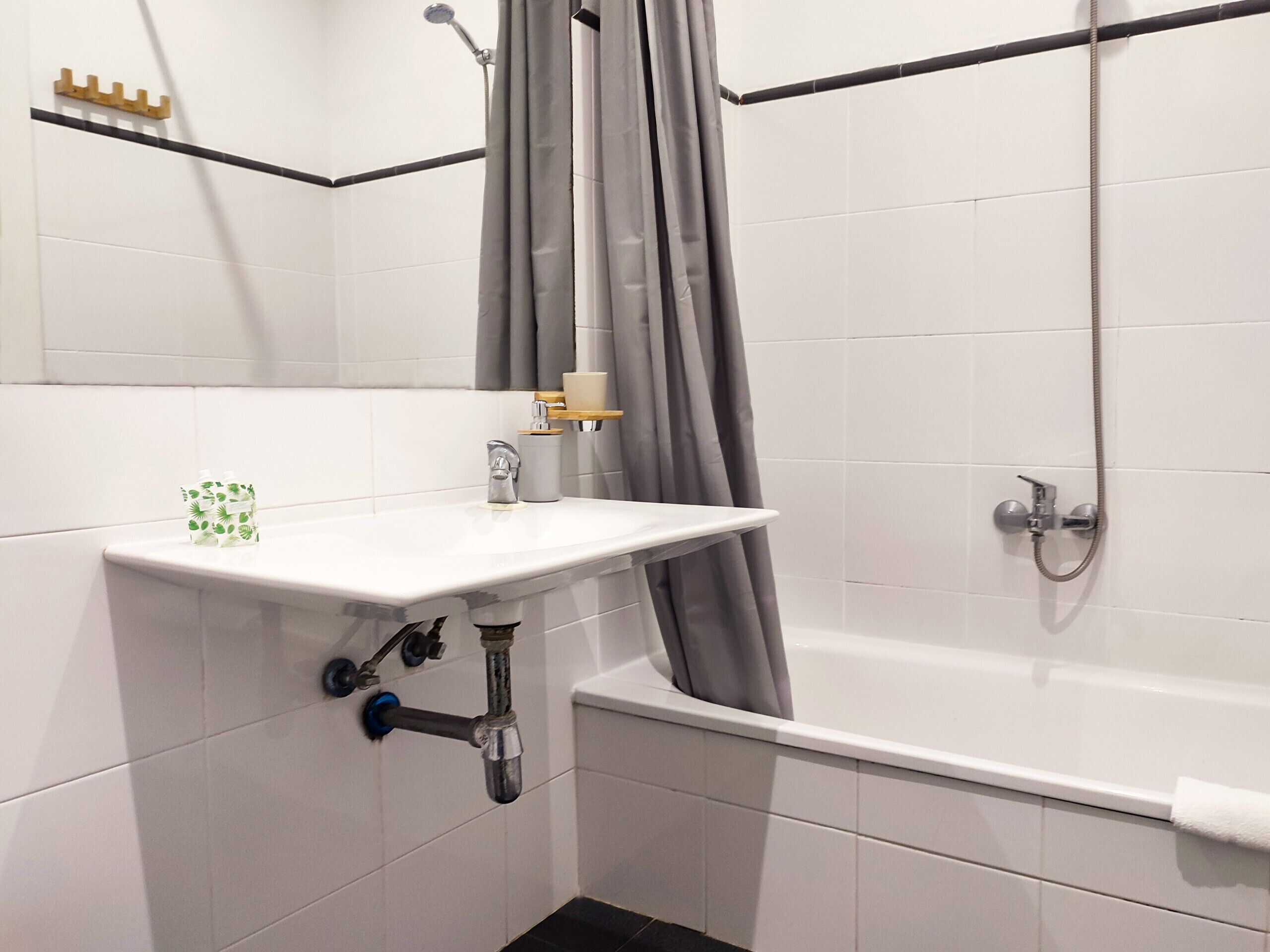 Une salle de bain avec un lavabo blanc, une douche et une baignoire.