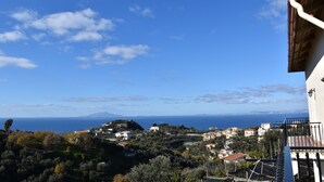 Una cittadina costiera con edifici, alberi e vista sul mare.