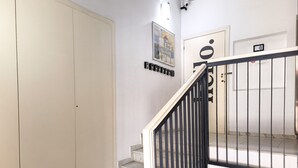 Eine Treppe mit schwarzer Geländer, eine Tür mit einem Schild und ein an der Wand befestigtes Telefon.