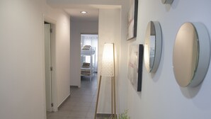 A hallway with a bed, a standing lamp, and a potted plant. - Flats Friends Tetuan 2 bedrooms (Valencia)