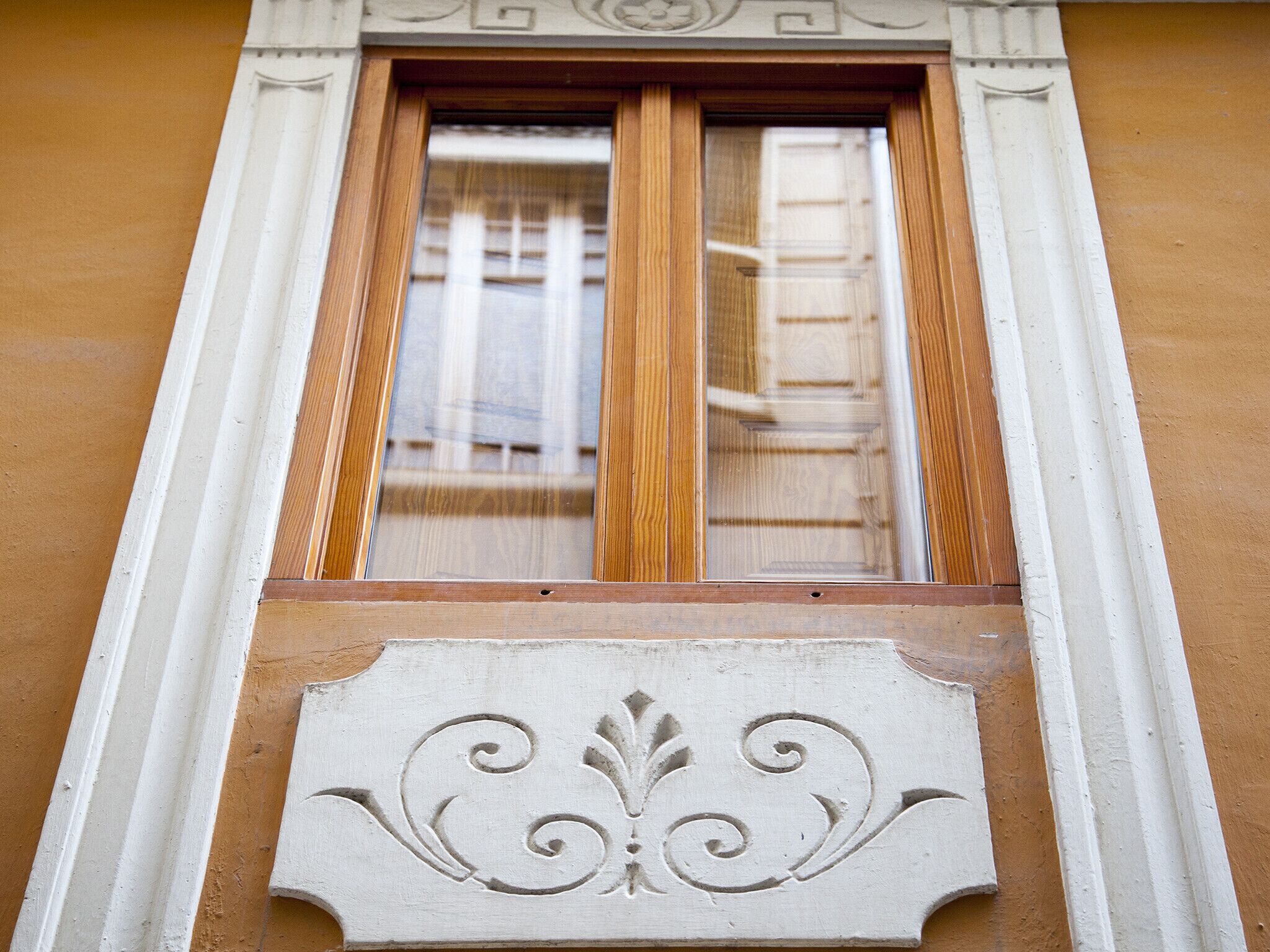 A window with a decorative mold trim and a wooden frame.